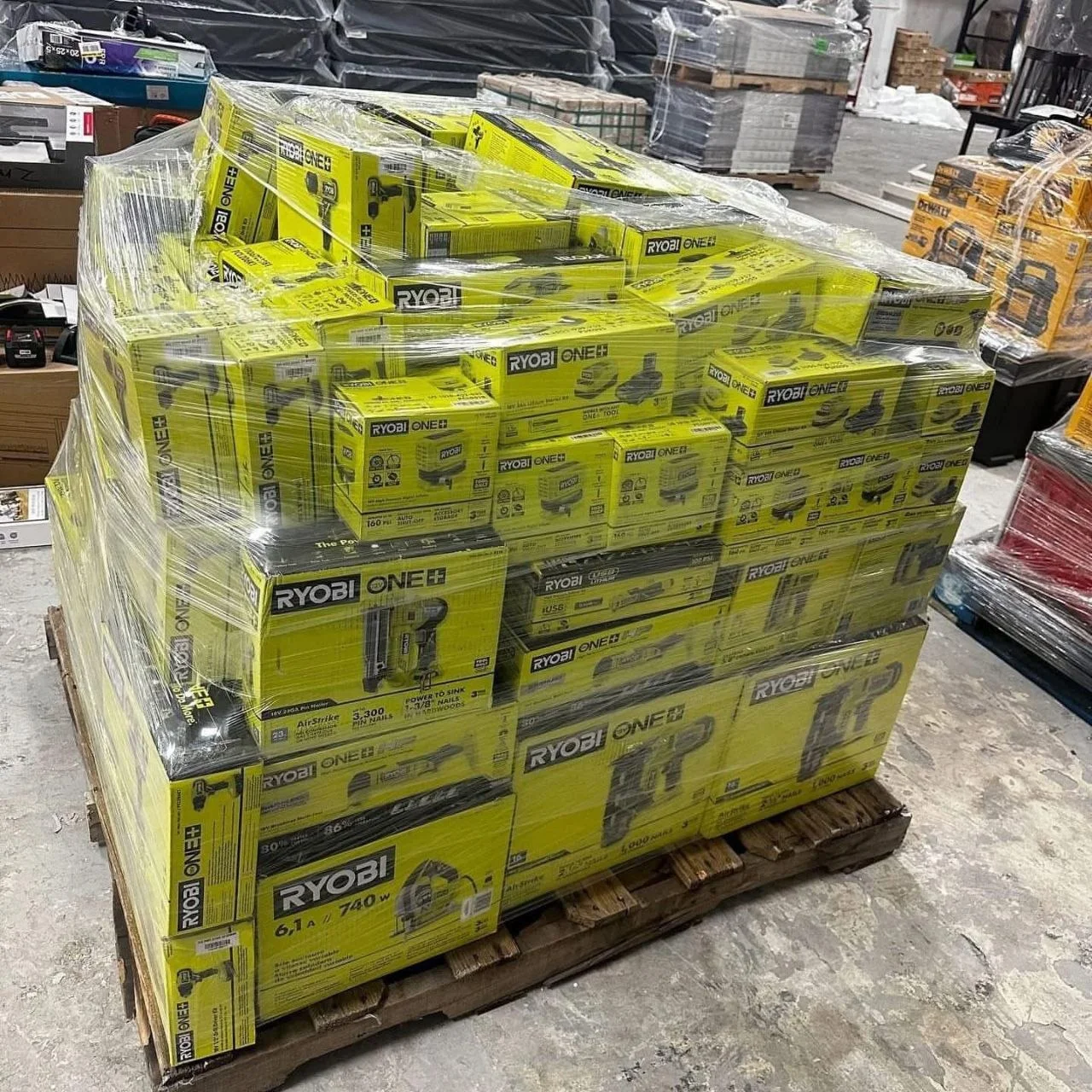 Ryobi tool liquidation pallet with assorted cordless drills, impact drivers, saws, batteries, chargers, and power tool accessories