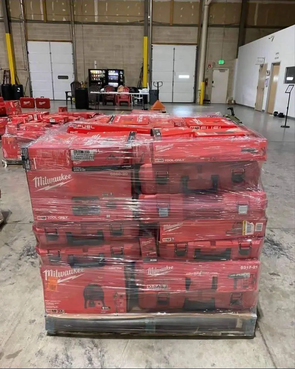 Wholesale Milwaukee tool assortment with batteries, chargers, work lights, and power-tool accessories.
