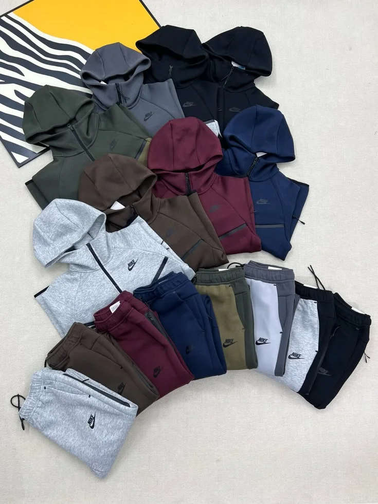 Wholesale tracksuit clothing liquidation pallet with assorted athletic jackets, joggers, hoodies, and sportswear