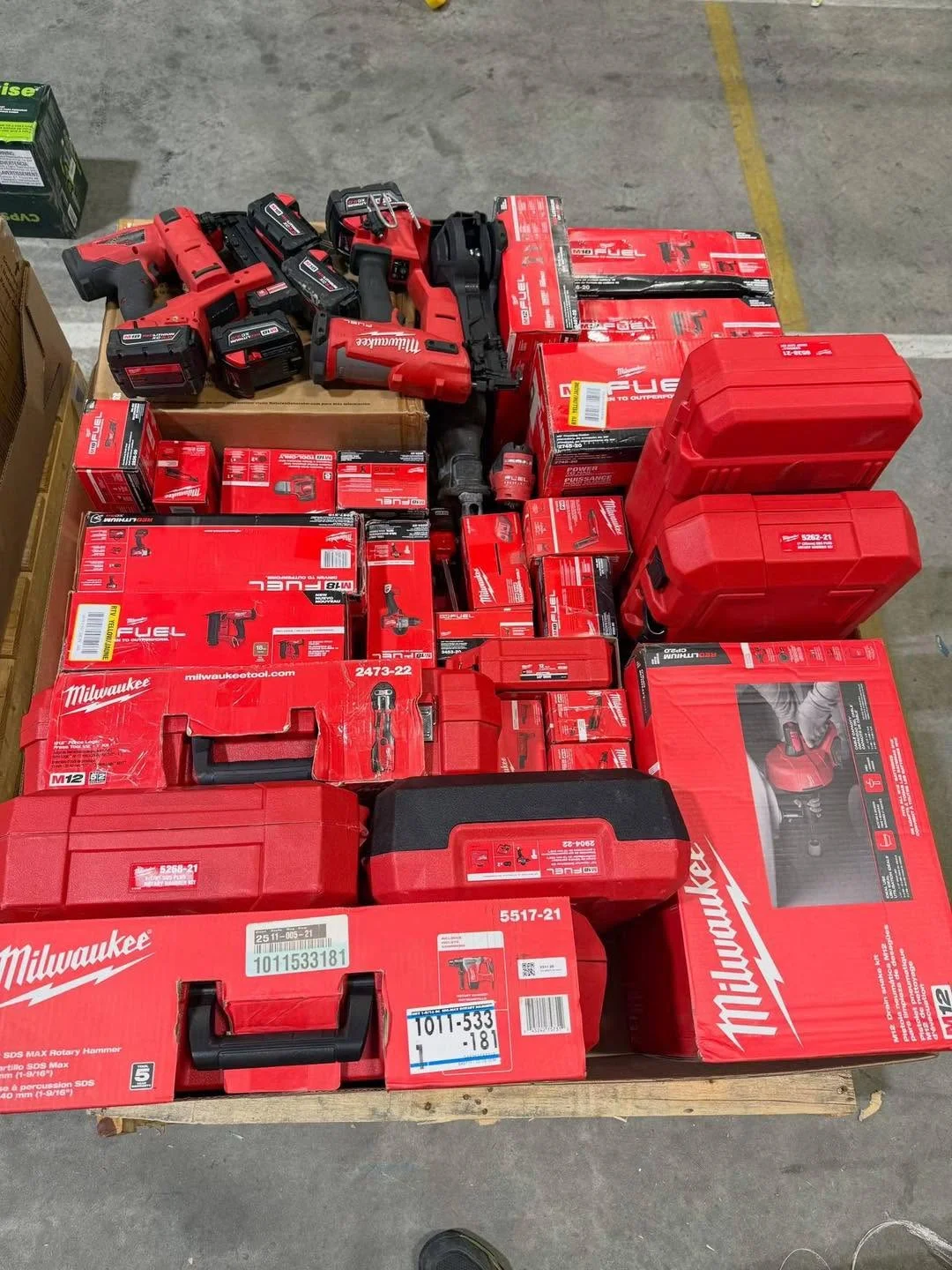 Wholesale Milwaukee tool assortment with batteries, chargers, work lights, and power-tool accessories.