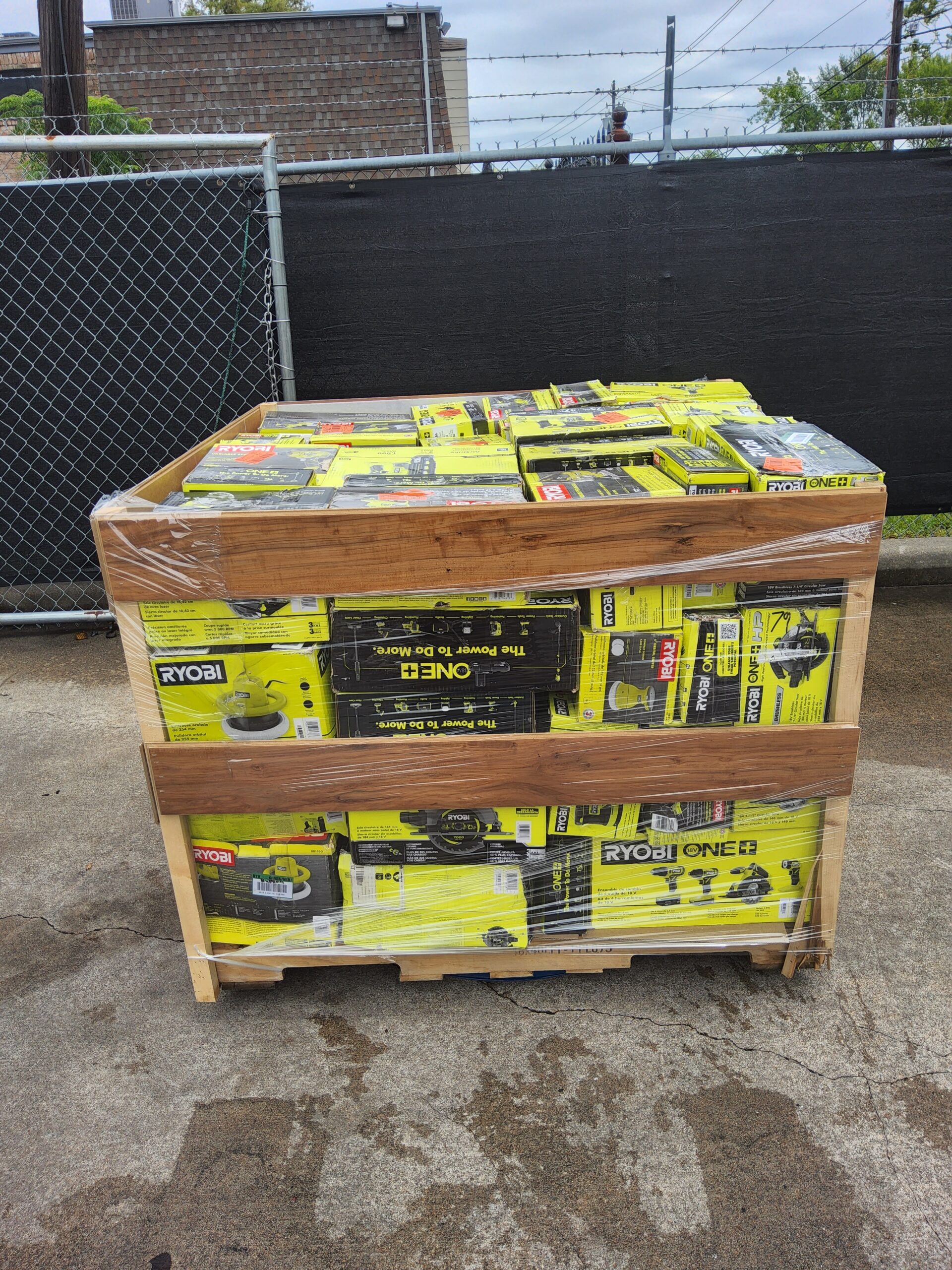 Ryobi tool liquidation pallet with assorted cordless drills, impact drivers, saws, batteries, chargers, and power tool accessories