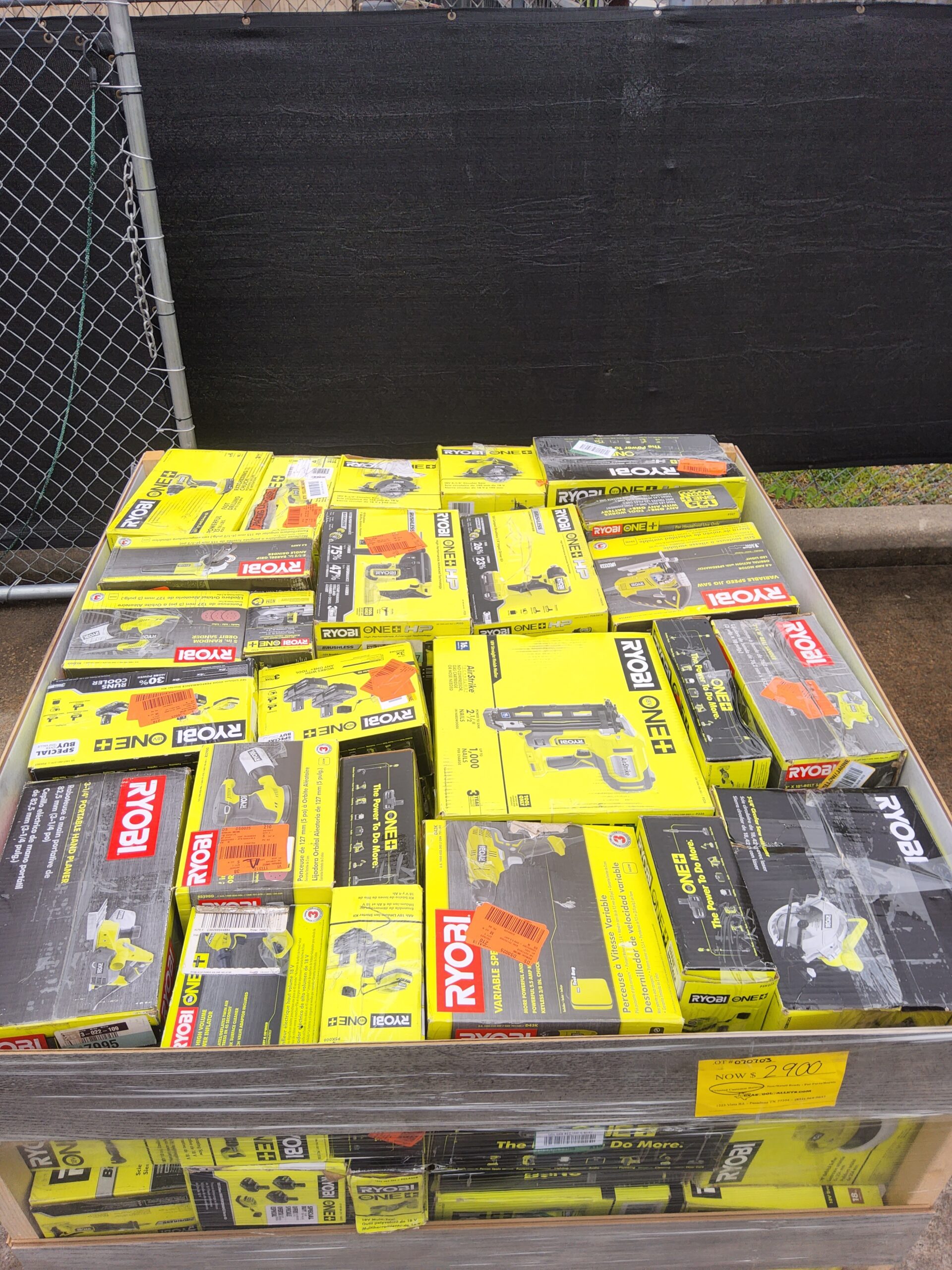 Ryobi tool liquidation pallet with assorted cordless drills, impact drivers, saws, batteries, chargers, and power tool accessories