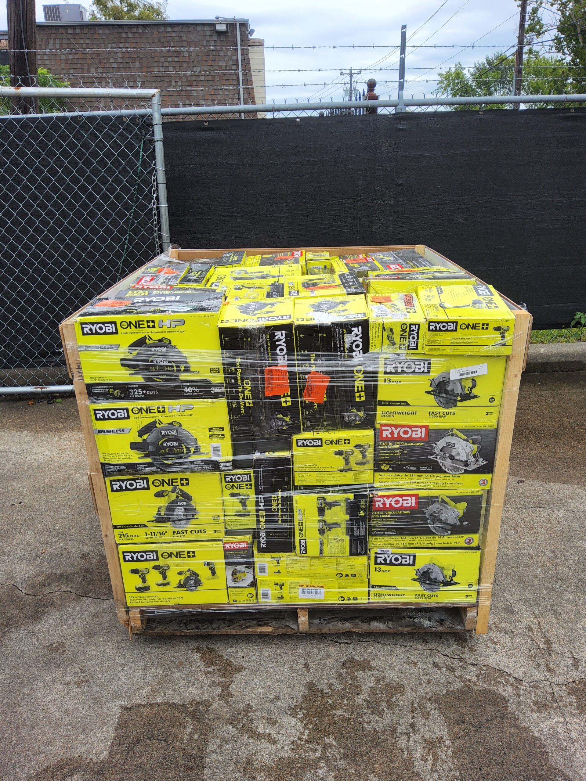 Ryobi tool liquidation pallet with assorted cordless drills, impact drivers, saws, batteries, chargers, and power tool accessories