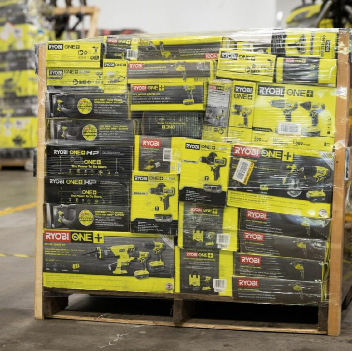 Ryobi tool liquidation pallet with assorted cordless drills, impact drivers, saws, batteries, chargers, and power tool accessories