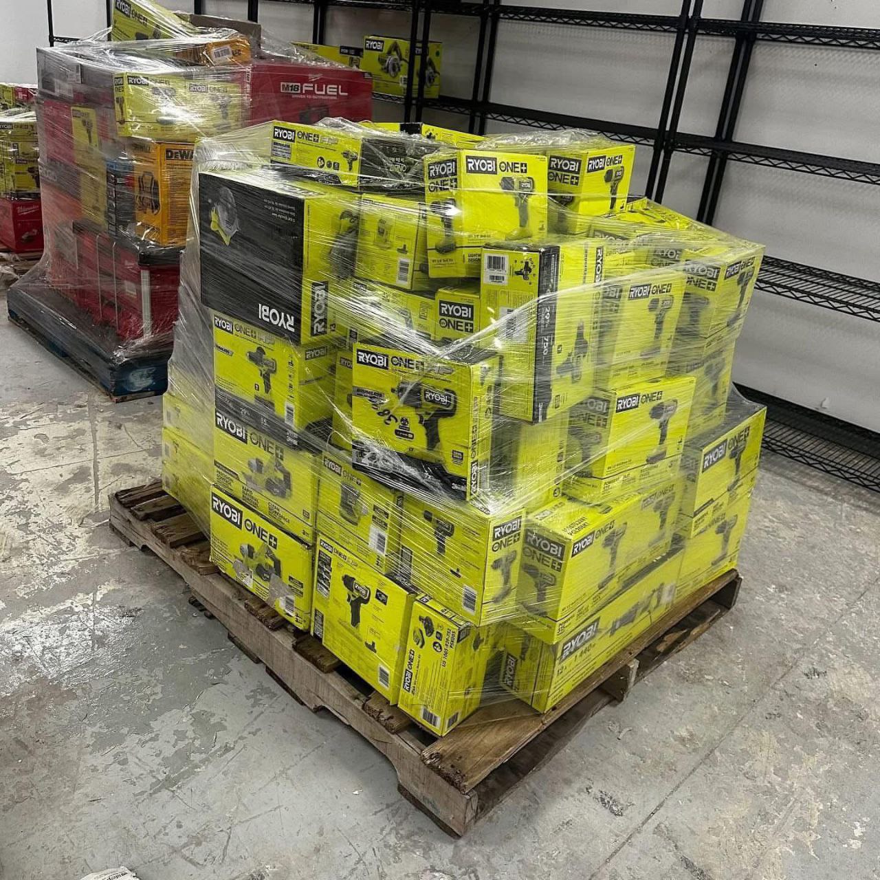 Ryobi tool liquidation pallet with assorted cordless drills, impact drivers, saws, batteries, chargers, and power tool accessories