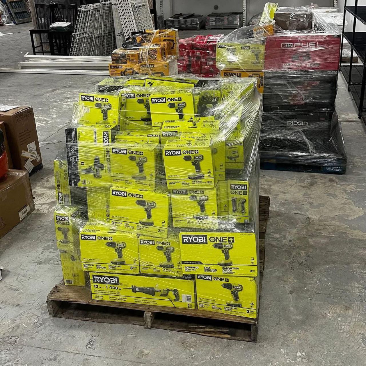 Ryobi tool liquidation pallet with assorted cordless drills, impact drivers, saws, batteries, chargers, and power tool accessories